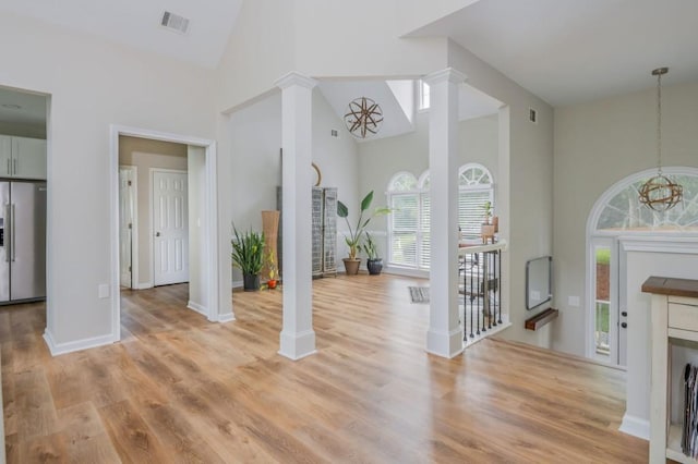 2045 Bethany Spring Trce, Cumming, GA 30041 - foyer entrance featuring decorative columns, high vaulted ceiling, light wood finished floors, and a chandelier