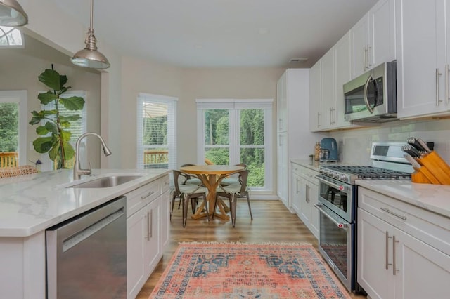 2045 Bethany Spring Trce, Cumming, GA 30041 - kitchen with appliances with stainless steel finishes, light wood-style floors, white cabinetry, and an island with sink