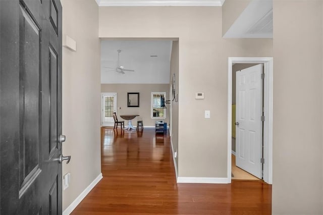 entryway featuring ornamental molding, wood finished floors, a ceiling fan, and baseboards