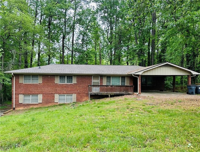 single story home featuring a carport, a front yard, a deck, and brick siding