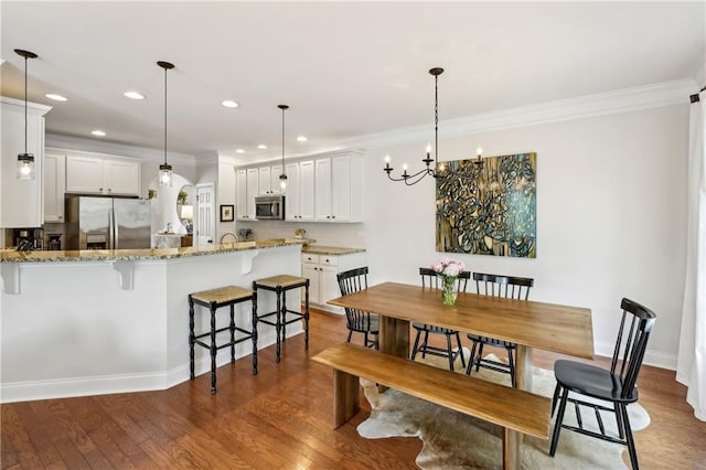 dining space featuring recessed lighting, baseboards, ornamental molding, a chandelier, and wood finished floors