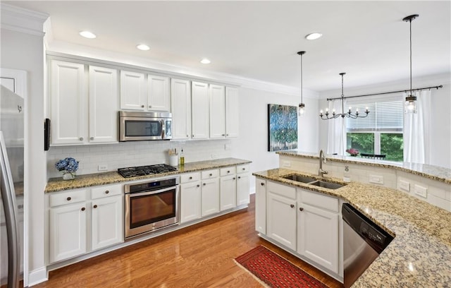 kitchen with a sink, ornamental molding, decorative backsplash, and appliances with stainless steel finishes