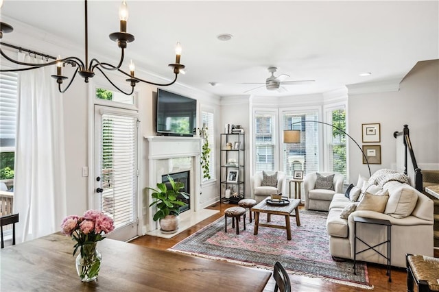 living area with crown molding, wood finished floors, and a healthy amount of sunlight