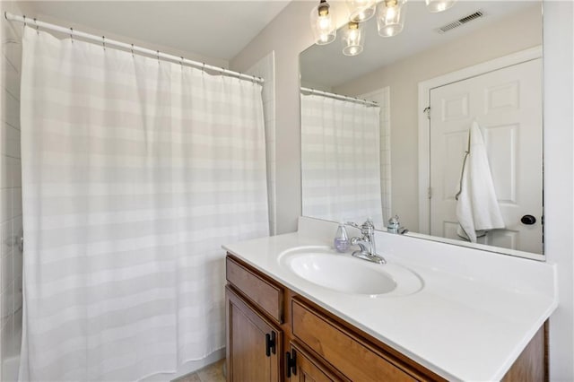 full bath with an inviting chandelier, vanity, and visible vents