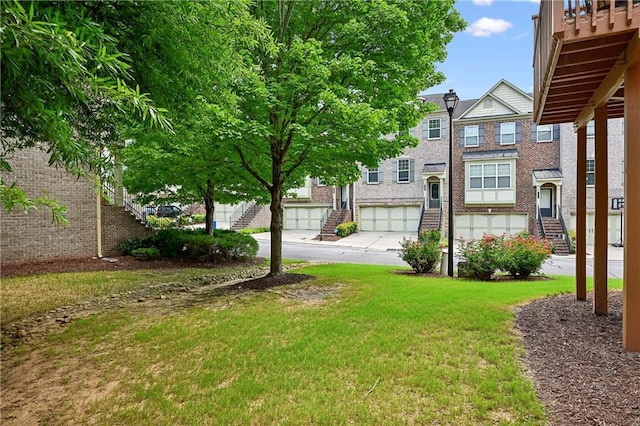 view of yard featuring driveway, stairway, and an attached garage