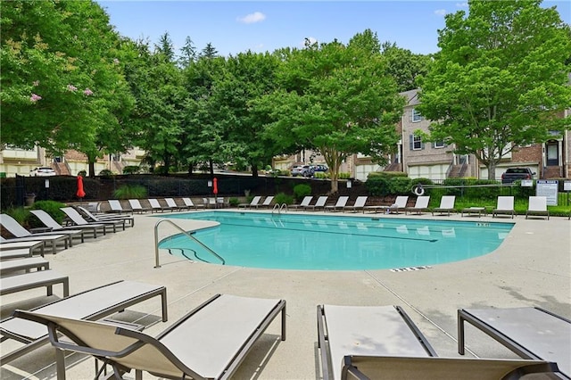 pool with a patio and fence