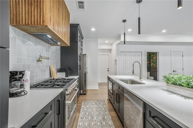 2809 Glenwood Ave SE, Atlanta, GA 30317 - kitchen featuring stainless steel appliances, a sink, wood finished floors, tasteful backsplash, and light countertops