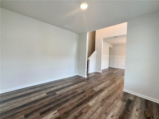 empty room with dark hardwood / wood-style flooring