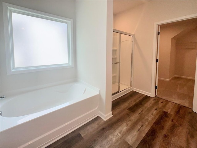 bathroom with wood-type flooring and plus walk in shower