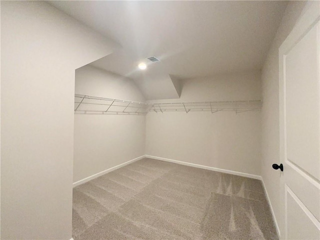 walk in closet with carpet and lofted ceiling