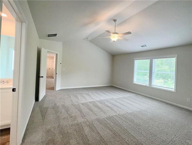 empty room with light colored carpet, vaulted ceiling, ceiling fan, and sink