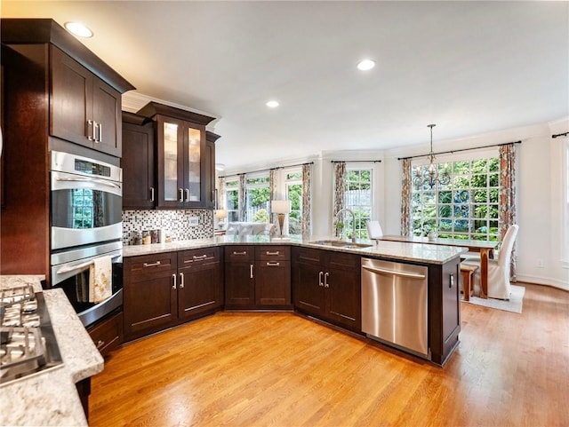 350 Fountain Oaks Ln, Atlanta, GA 30342 - kitchen featuring stainless steel appliances, light wood-type flooring, plenty of natural light, dark brown cabinets, and crown molding