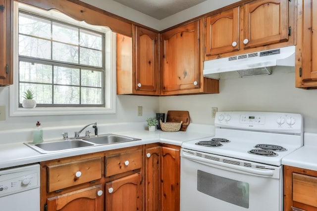 798 Tommy Lee Cook Rd, Palmetto, GA 30268 - kitchen with white appliances, under cabinet range hood, brown cabinets, and light countertops