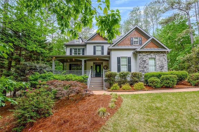 craftsman house with covered porch, stairs, and a front lawn