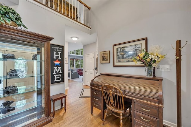 home office with baseboards and light wood-style floors