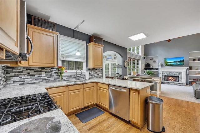 kitchen with a sink, light brown cabinetry, light wood-type flooring, and dishwasher
