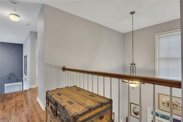 corridor with visible vents, baseboards, and wood finished floors
