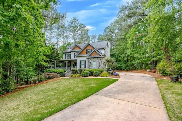craftsman house featuring a front lawn, covered porch, stone siding, concrete driveway, and stairway