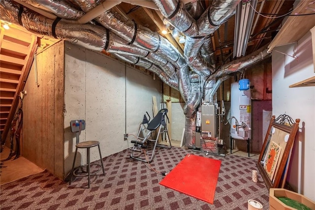 unfinished basement with carpet floors, heating unit, and gas water heater