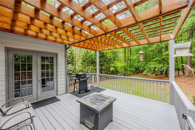 wooden terrace with a pergola, french doors, and a grill