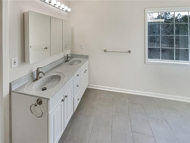 full bathroom featuring a sink, baseboards, and double vanity