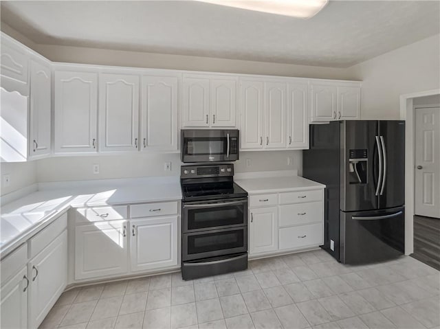 kitchen featuring white cabinets, stainless steel appliances, and light countertops