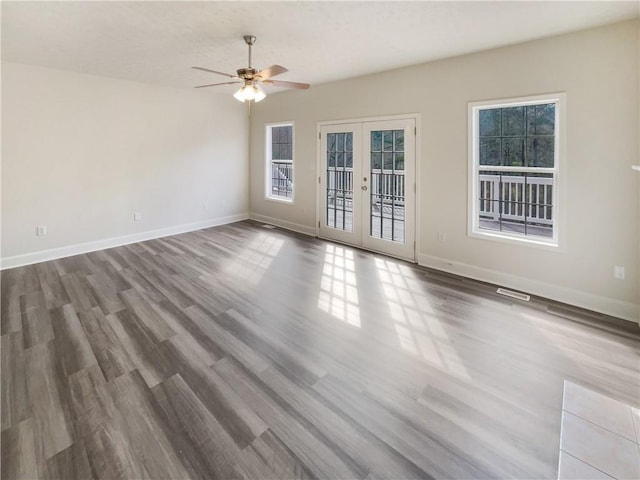 spare room with visible vents, french doors, baseboards, and wood finished floors