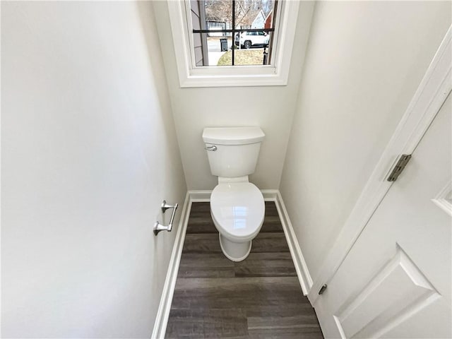 bathroom with baseboards, toilet, and wood finished floors