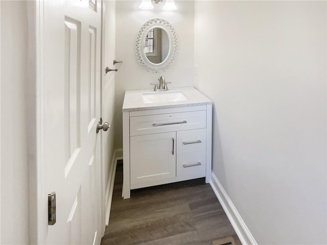 bathroom featuring vanity, baseboards, and wood finished floors