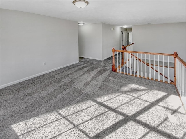 spare room with baseboards and carpet floors