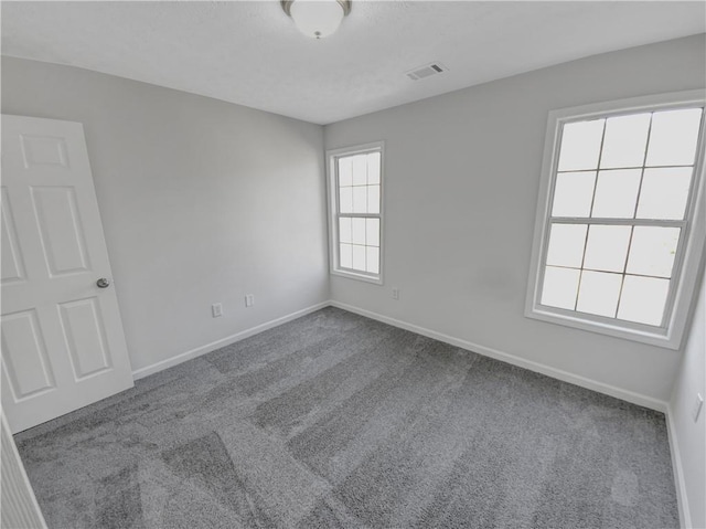 unfurnished room with visible vents, a textured ceiling, baseboards, and carpet floors