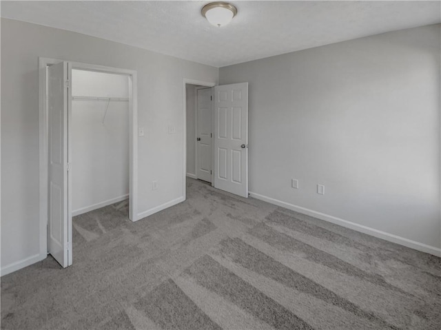 unfurnished bedroom featuring a closet, a textured ceiling, carpet, and baseboards