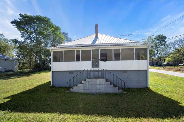 back of property featuring a lawn and a sunroom