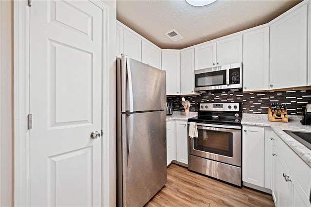 200 High Creek Dr, Roswell, GA 30076 - kitchen with backsplash, white cabinetry, visible vents, and stainless steel appliances