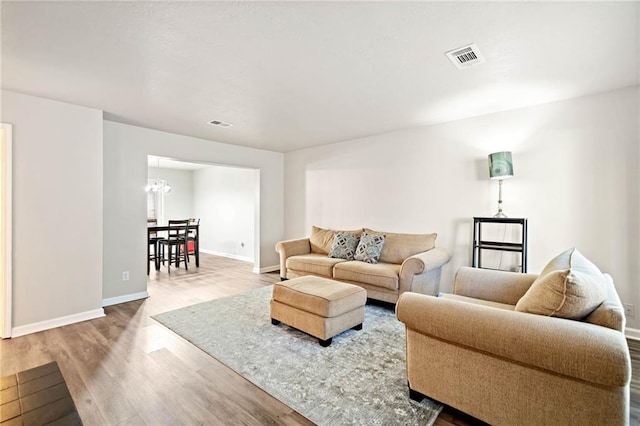200 High Creek Dr, Roswell, GA 30076 - living room with wood finished floors, baseboards, visible vents, and a notable chandelier
