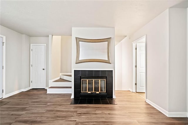 200 High Creek Dr, Roswell, GA 30076 - unfurnished living room featuring a tile fireplace, baseboards, and wood finished floors