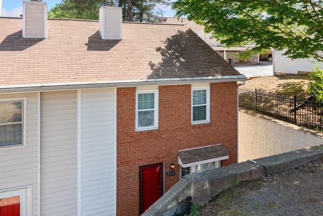 200 High Creek Dr, Roswell, GA 30076 - view of home's exterior featuring brick siding, fence, and a chimney