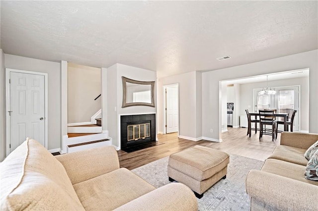 200 High Creek Dr, Roswell, GA 30076 - living area featuring a notable chandelier, baseboards, stairs, visible vents, and wood finished floors
