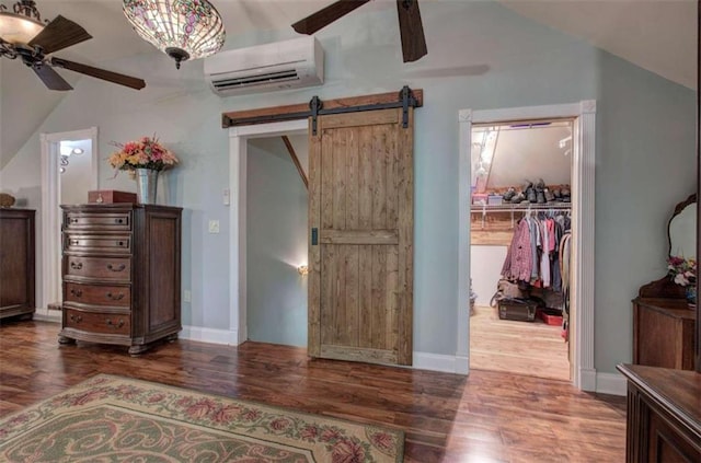 bedroom with a wall unit AC, a barn door, a closet, and wood-type flooring