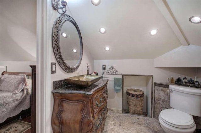 bathroom with vanity, vaulted ceiling, and toilet