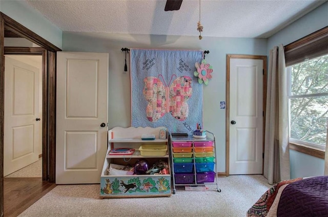 carpeted bedroom featuring a textured ceiling and ceiling fan