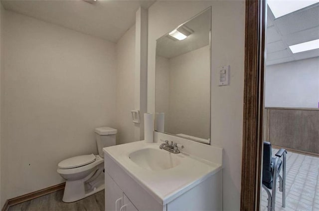 bathroom featuring toilet, hardwood / wood-style flooring, and vanity