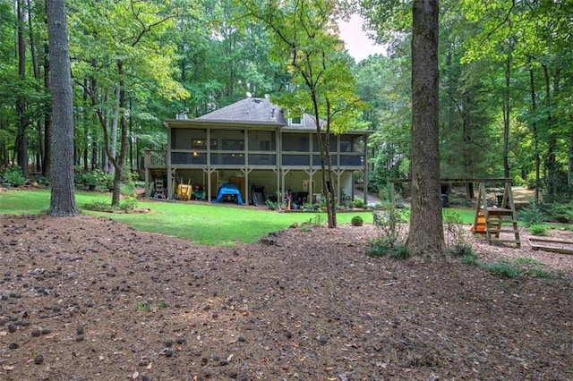 back of house with a yard and a sunroom