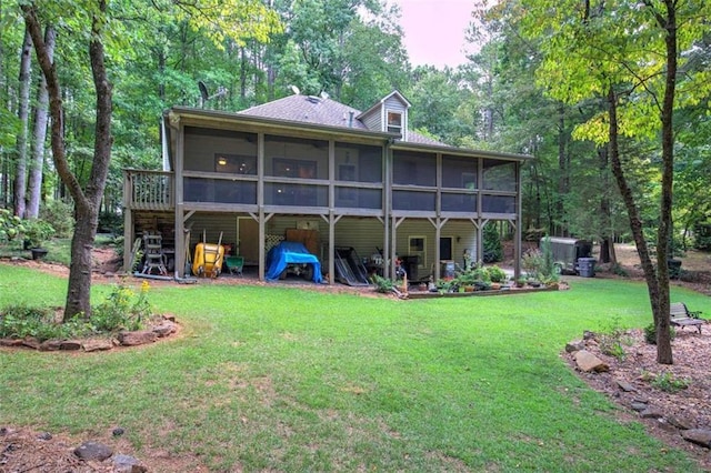 rear view of house with a yard and a sunroom