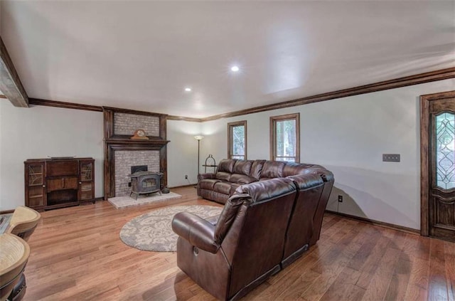 living room featuring ornamental molding, hardwood / wood-style flooring, and a wood stove