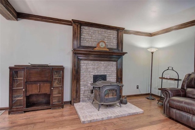 living room featuring a wood stove, ornamental molding, and light wood-type flooring