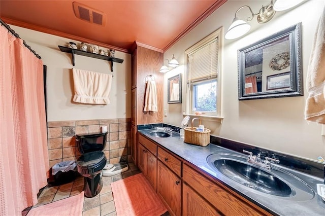 bathroom with crown molding, tile patterned floors, tile walls, and vanity