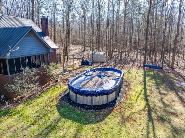 view of yard featuring a covered pool and a sunroom