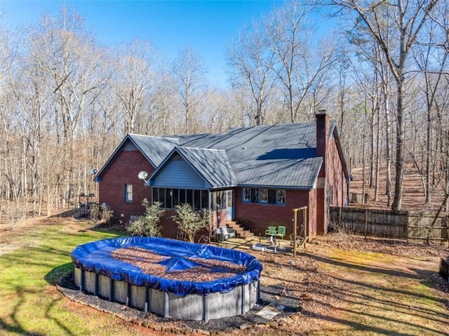 rear view of house with a covered pool