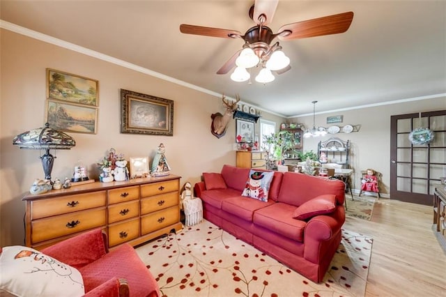 living room with ceiling fan with notable chandelier, light hardwood / wood-style flooring, and ornamental molding